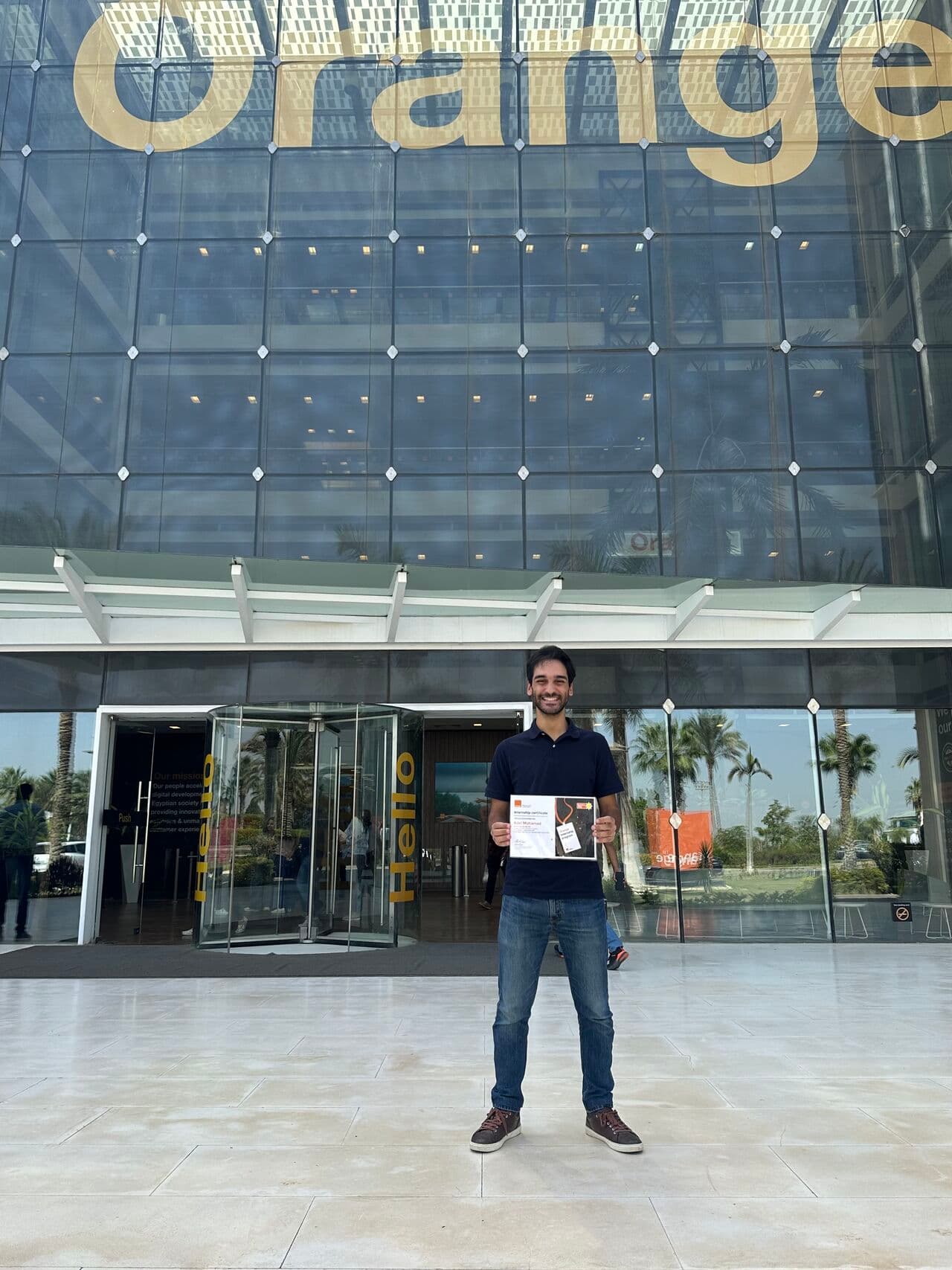 Adel outside an Orange Egypt building during the internship